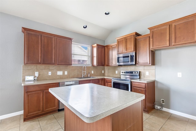 kitchen with a center island, lofted ceiling, sink, light tile patterned floors, and stainless steel appliances