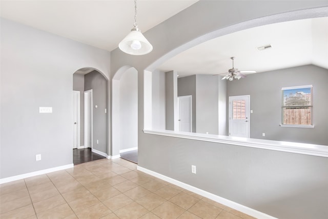 tiled empty room featuring ceiling fan and lofted ceiling