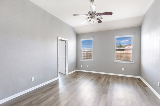 empty room featuring ceiling fan, wood-type flooring, and vaulted ceiling