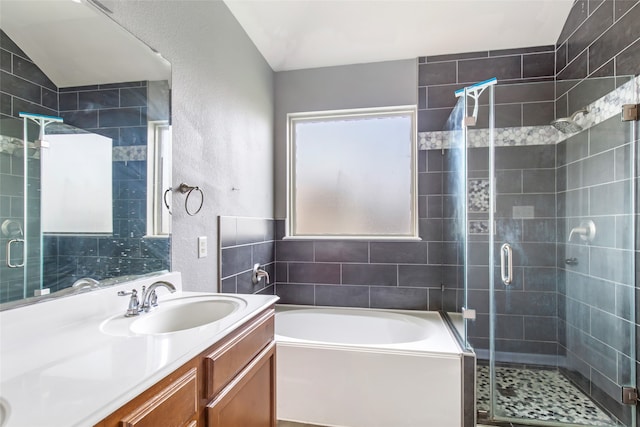 bathroom featuring vanity, independent shower and bath, and vaulted ceiling