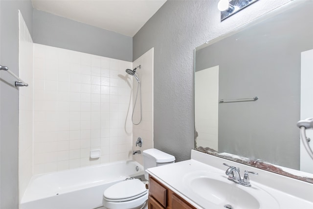 full bathroom featuring tiled shower / bath, vanity, and toilet