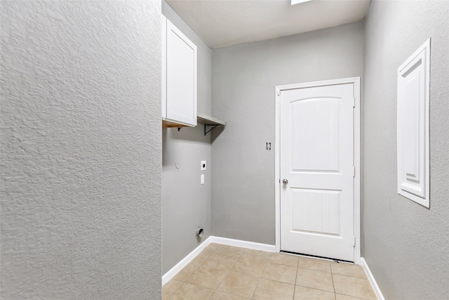 laundry area featuring electric dryer hookup and light tile patterned floors