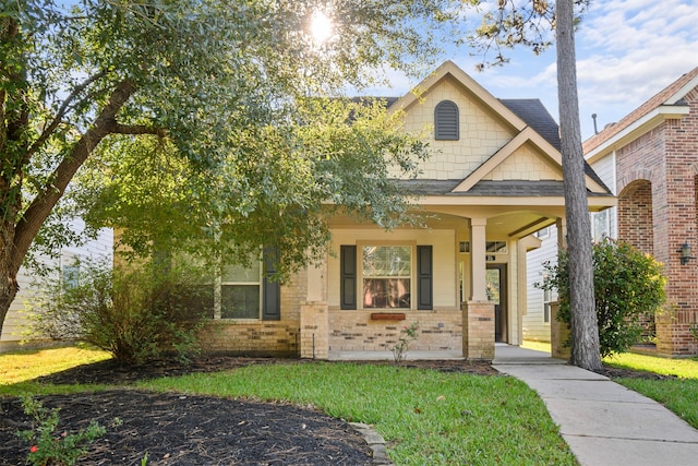 craftsman-style house featuring covered porch and a front yard