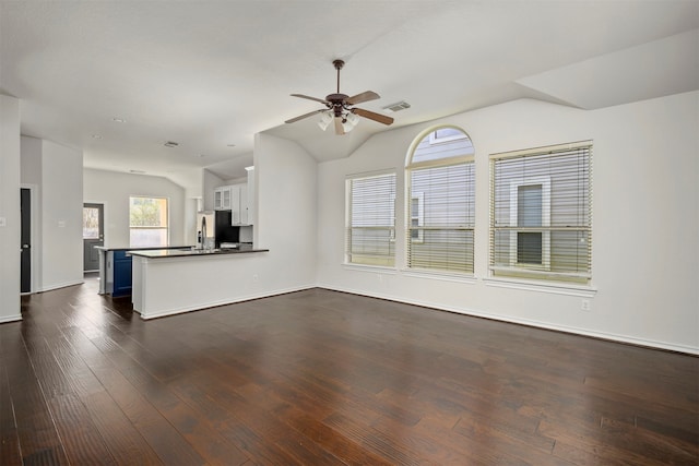 unfurnished living room featuring dark hardwood / wood-style floors, ceiling fan, and lofted ceiling