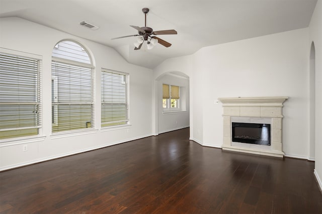 unfurnished living room featuring a tile fireplace, ceiling fan, dark wood-type flooring, and lofted ceiling