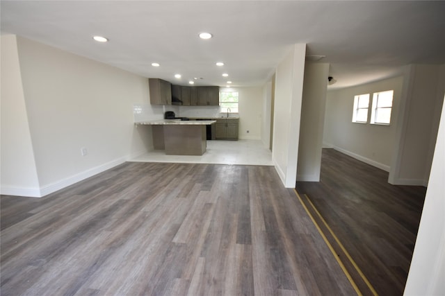 unfurnished living room featuring dark hardwood / wood-style floors and sink