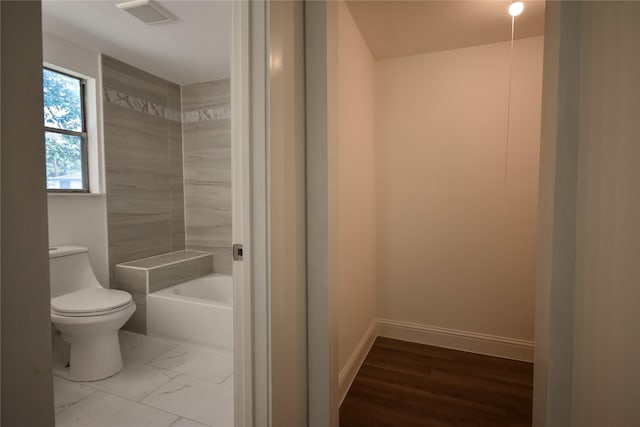 314 Reese Rd, Crosby, TX 77532 - bathroom with a bath, toilet, baseboards, and marble look tiles