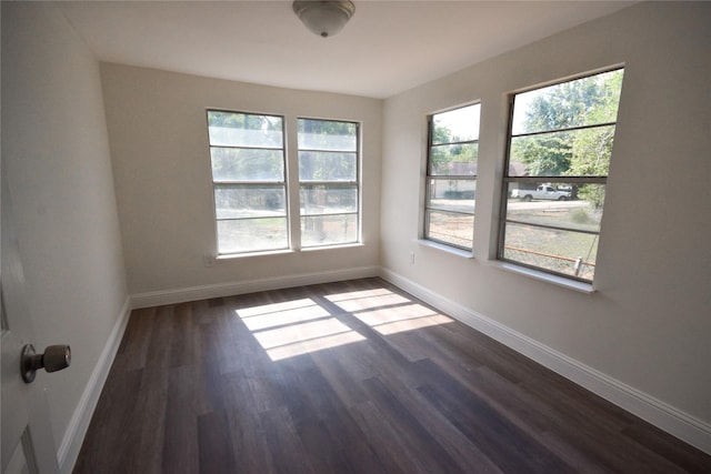 spare room with dark hardwood / wood-style floors and a healthy amount of sunlight