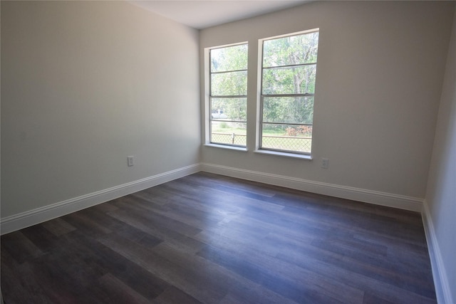 unfurnished room featuring a wealth of natural light and dark hardwood / wood-style flooring