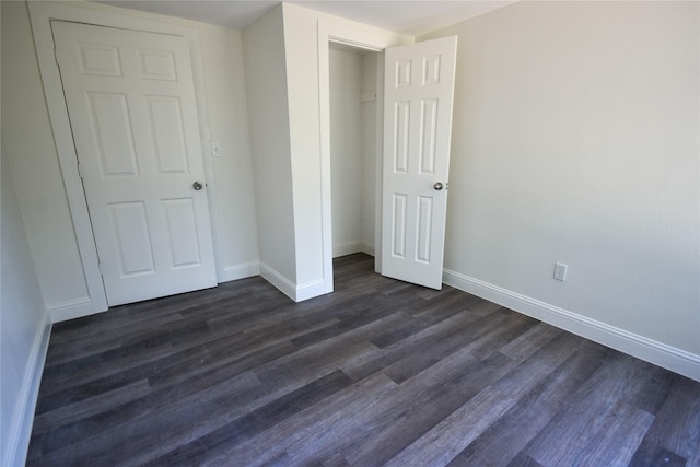 unfurnished bedroom with a closet and dark hardwood / wood-style flooring