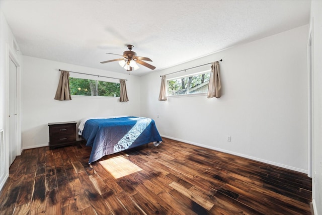 bedroom with ceiling fan, a textured ceiling, baseboards, and wood finished floors