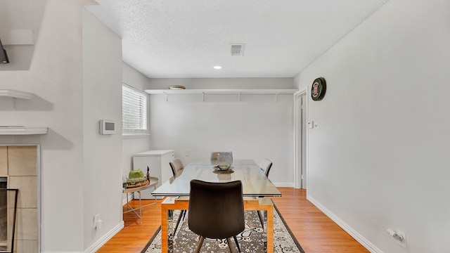 dining area with a textured ceiling and hardwood / wood-style flooring