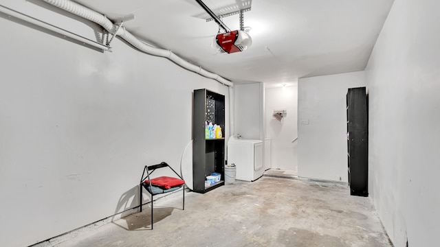 garage with independent washer and dryer and a garage door opener