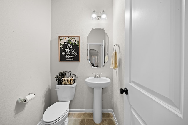 bathroom featuring tile patterned flooring, toilet, and sink