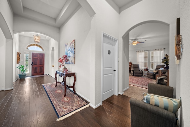 entryway featuring dark hardwood / wood-style flooring and ceiling fan with notable chandelier