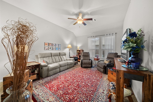 carpeted living room with ceiling fan and vaulted ceiling