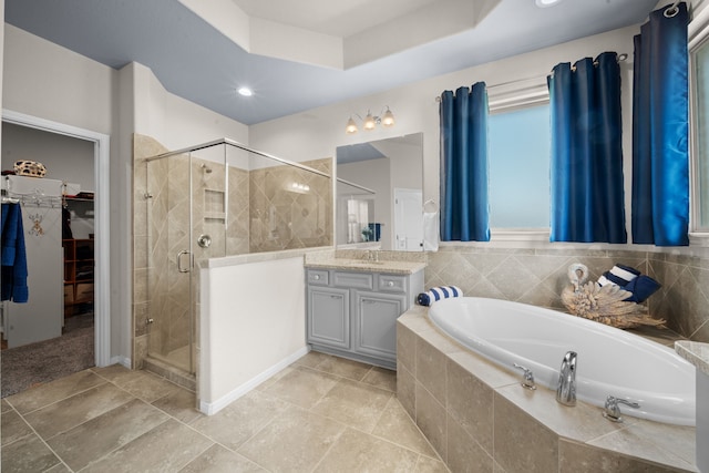 bathroom featuring tile patterned floors, vanity, separate shower and tub, and a raised ceiling