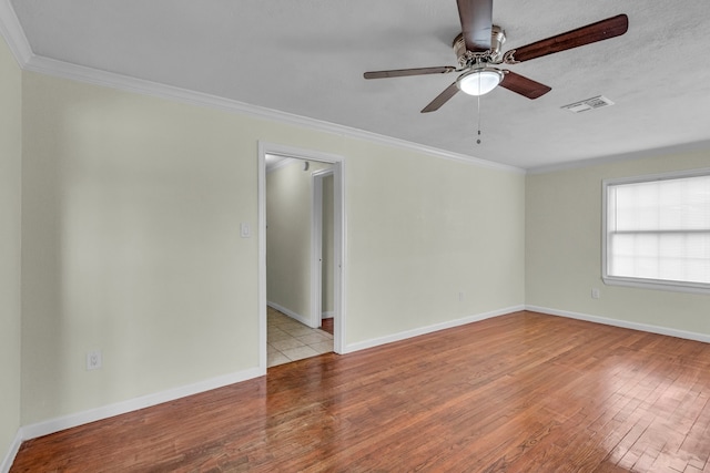 spare room with ceiling fan, light wood-type flooring, and ornamental molding