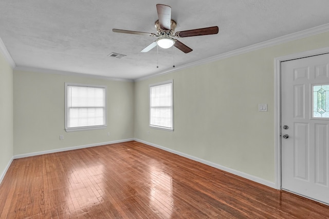 entryway featuring hardwood / wood-style flooring, a wealth of natural light, ornamental molding, and ceiling fan