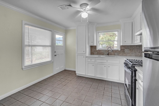 kitchen featuring ceiling fan, sink, decorative backsplash, white cabinets, and appliances with stainless steel finishes