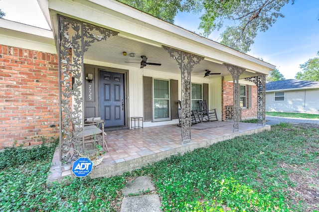 view of exterior entry featuring ceiling fan and covered porch