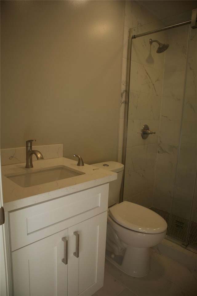 bathroom featuring toilet, vanity, tile patterned floors, and a shower with door