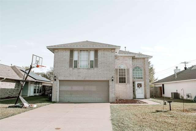 view of front of house featuring a front yard, central AC unit, and a garage