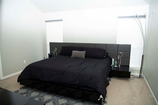 bedroom featuring light carpet and vaulted ceiling