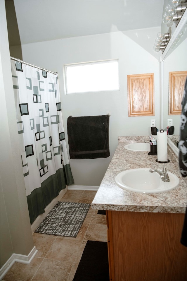 bathroom featuring tile patterned flooring, vanity, and lofted ceiling