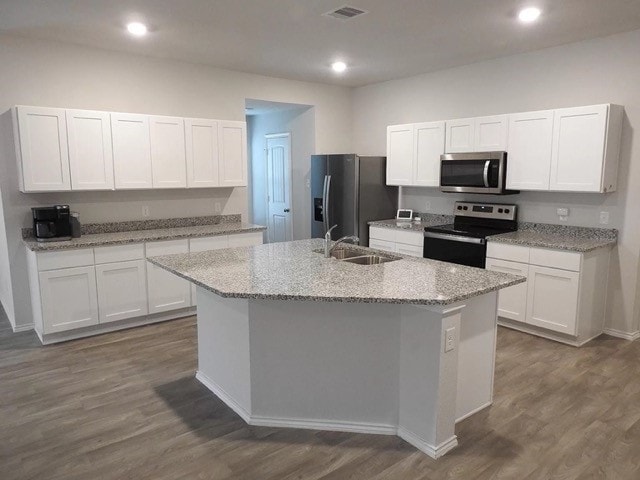 kitchen featuring sink, stainless steel appliances, dark hardwood / wood-style flooring, a center island with sink, and white cabinets