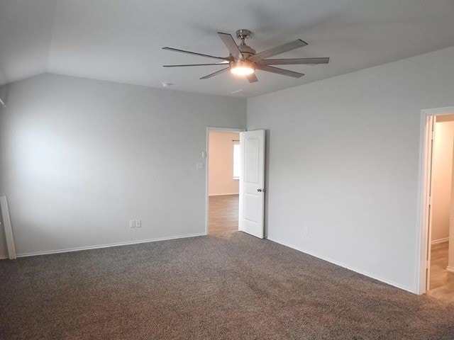 carpeted spare room with ceiling fan and vaulted ceiling