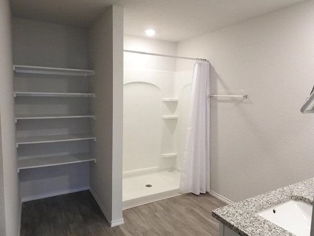 bathroom with a shower with shower curtain, wood-type flooring, and vanity