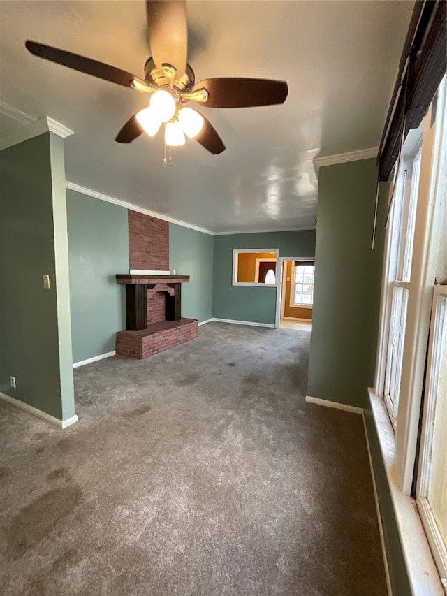 unfurnished living room with a fireplace, carpet, ceiling fan, and crown molding