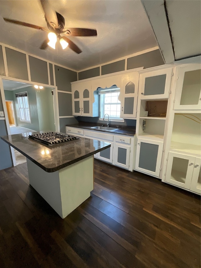 kitchen with a center island, dark hardwood / wood-style flooring, white cabinetry, and sink