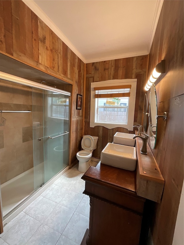 bathroom featuring wood walls, a shower with door, and crown molding