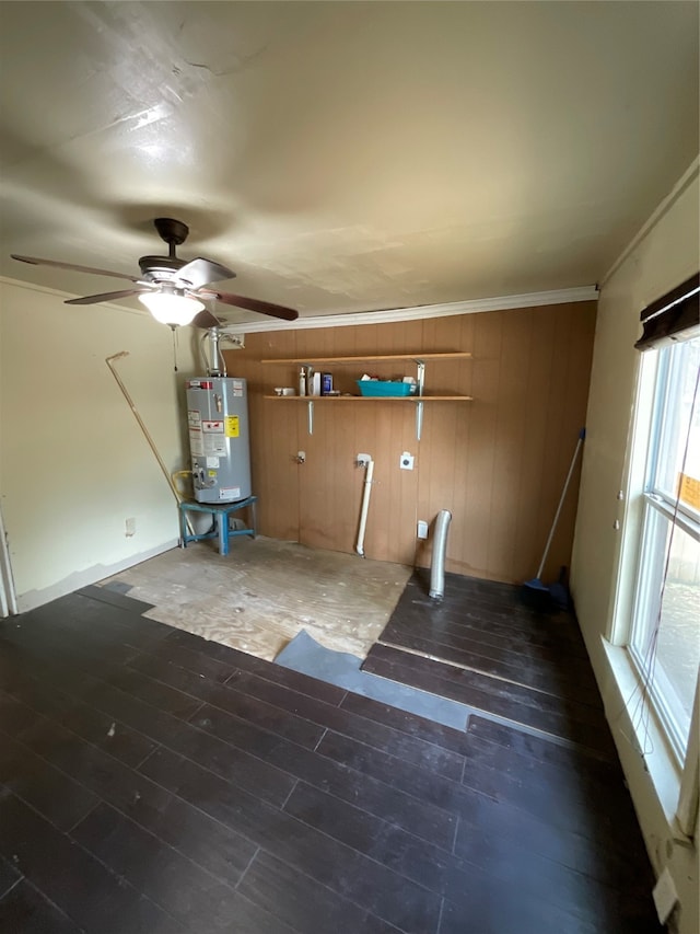 interior space with ceiling fan, water heater, dark hardwood / wood-style flooring, wood walls, and ornamental molding