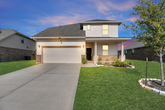 view of front of home featuring a yard, a porch, and a garage