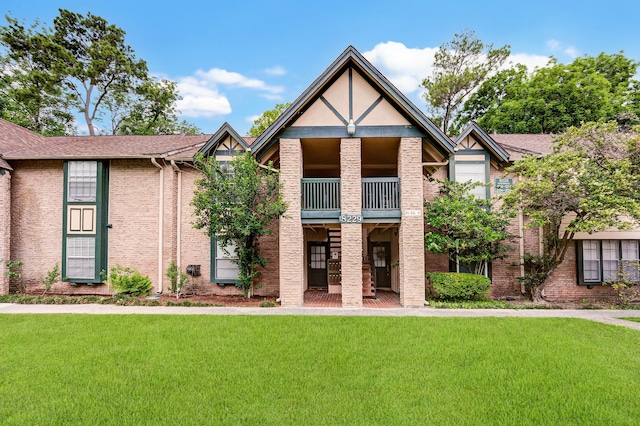 view of front of home featuring a balcony and a front lawn