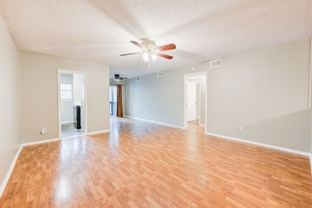 empty room featuring ceiling fan, light hardwood / wood-style floors, and a textured ceiling