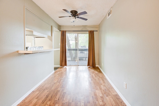 unfurnished room with ceiling fan, light hardwood / wood-style floors, and a textured ceiling