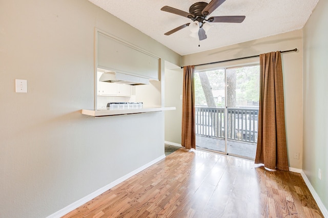 empty room featuring ceiling fan, light hardwood / wood-style floors, and a textured ceiling