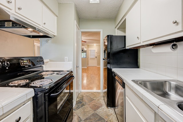 kitchen with electric range, stainless steel dishwasher, a textured ceiling, tile counters, and white cabinetry