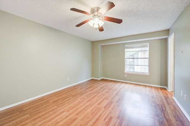 spare room featuring a textured ceiling, light wood-type flooring, and ceiling fan