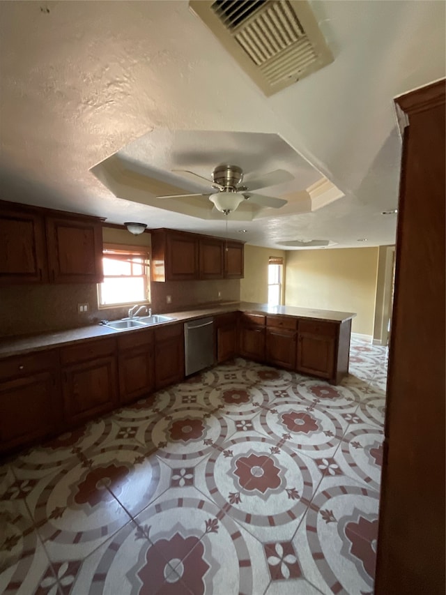 kitchen with dishwasher, a raised ceiling, kitchen peninsula, and sink