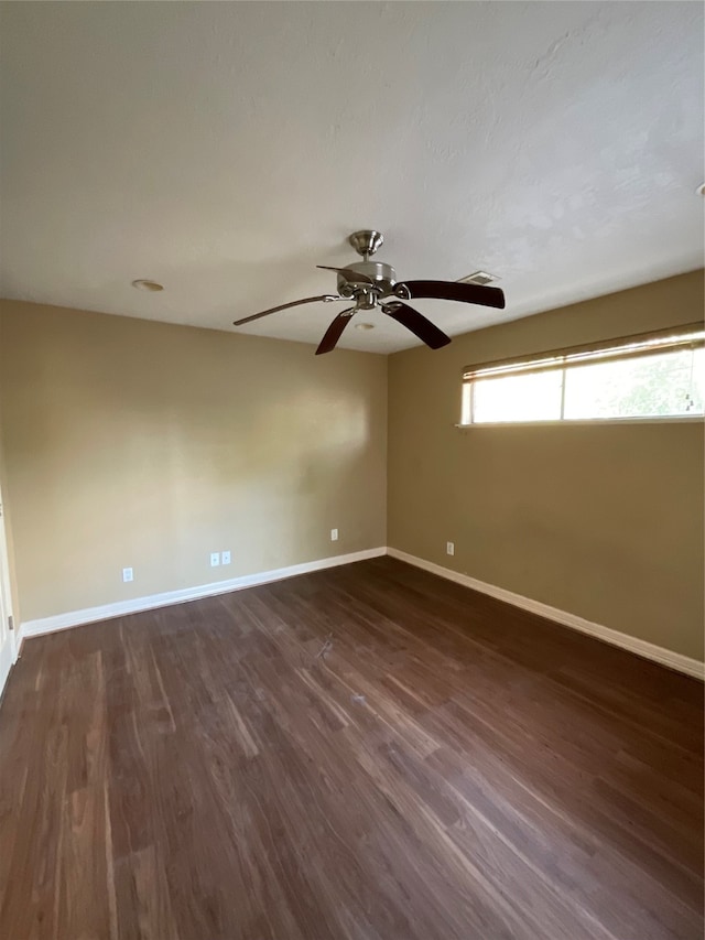 unfurnished room with ceiling fan and dark wood-type flooring