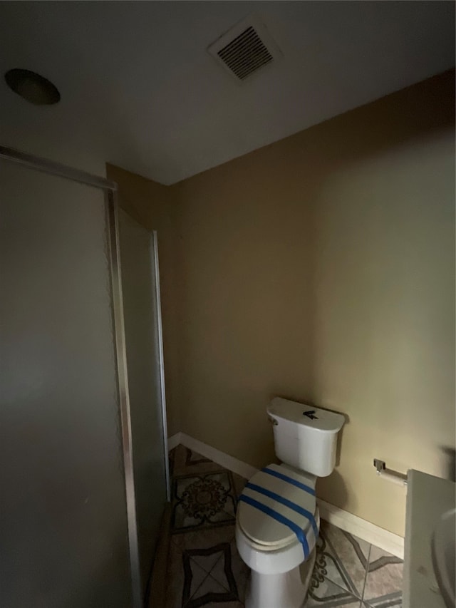 bathroom featuring walk in shower, tile patterned floors, vanity, and toilet