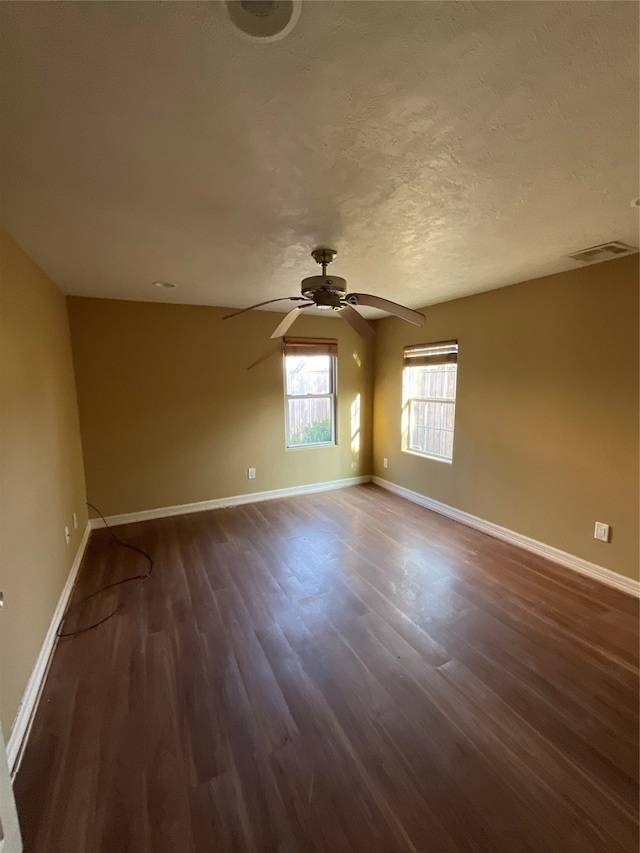 unfurnished room with dark hardwood / wood-style floors and a textured ceiling