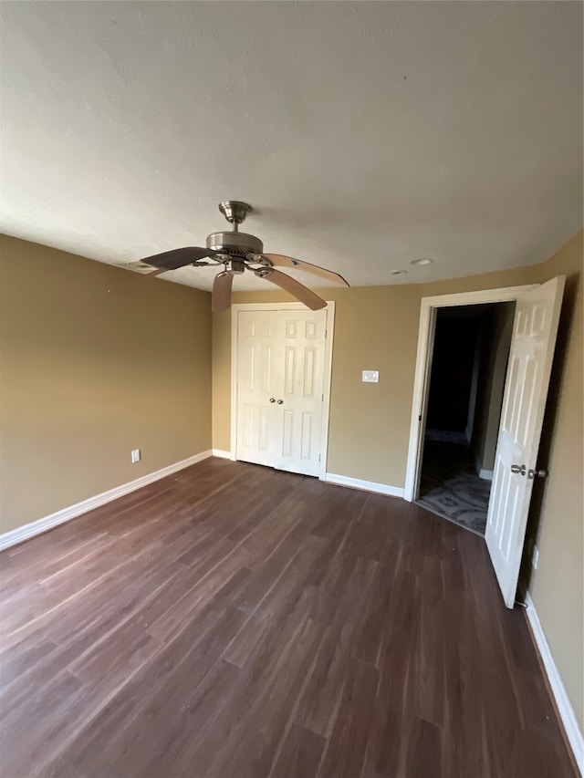 unfurnished bedroom featuring ceiling fan, a closet, and dark hardwood / wood-style floors