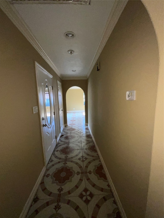 hallway with tile patterned floors and ornamental molding