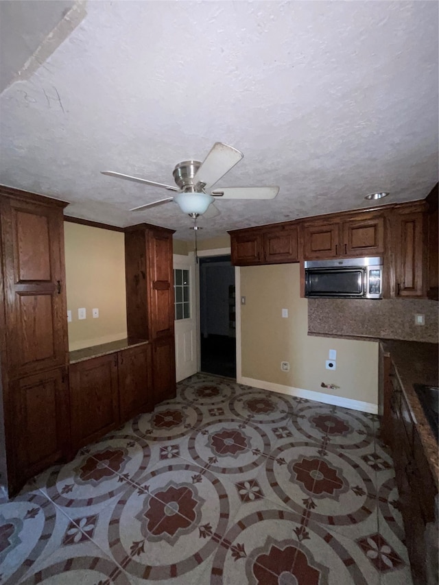 kitchen with a textured ceiling, backsplash, and ceiling fan